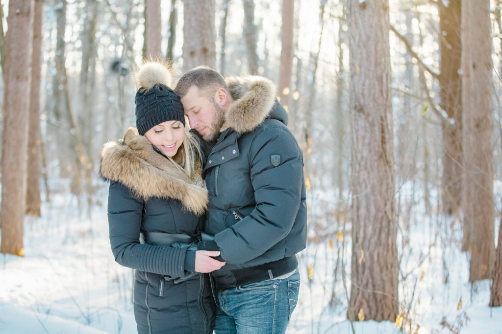 Couple wearing cute winter outfit with glam makeup during a cold winter engagement session at Pine Grove Trail Ottawa