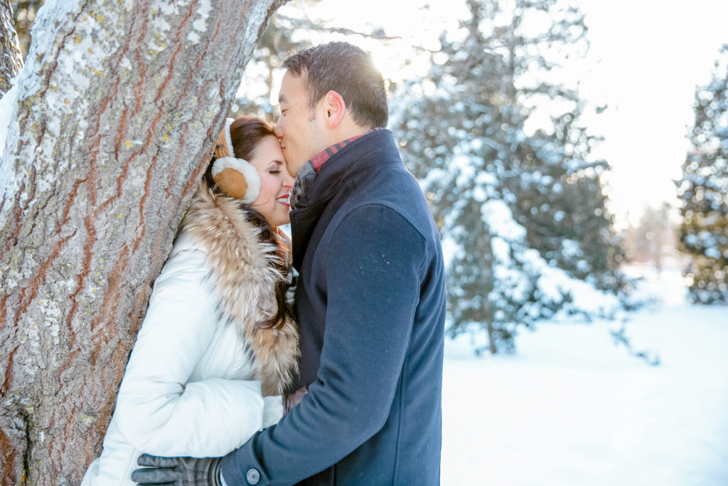 cute winter wonderland photo of couple during an engagement session in the dominion arboretum with cute accessories for winter 