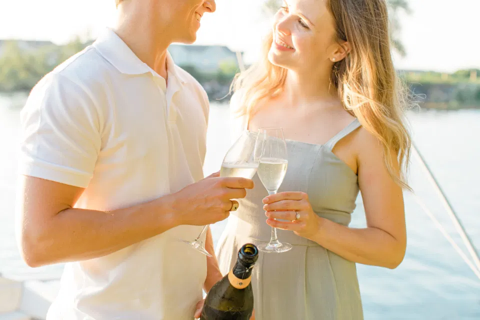 Pop the Champagne - Ideas for what to wear for Engagement Photography, Modern Engagement Session Inspiration Wardrobe Ideas. Unsure of what to wear for your engagement photos, we've got you! Romantic blue Romper and neutral Shirts and polo. Boat Shoes and Flip Flops. Engagement in Gananoque. Grey Loft Studio is Ottawa's Wedding and Engagement Photographer Videographer for Real couples, showcasing photos that are modern, bright, and fun.
